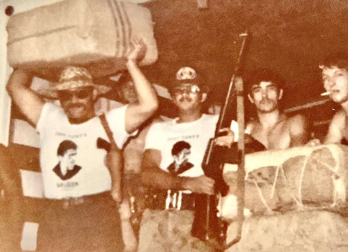 One of my favorite Keith photographs 1978 ninty pound bales of Columbian Carried out by the local sheriff with captain Tony T-shirts on a bunch of M-16s and the prisoners from the county jail helping to unload That weed was really amazing there is so many stories behind this photo